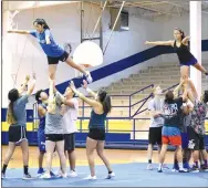  ?? Westside Eagle Observer/MIKE ECKELS ?? With their bases and spotters performing perfectly, flyers Stephanie Sandoval (upper left) and Kaylee Morales (upper right) hold a classic Arabesque maneuver during the morning training session of the July 12 Bulldog Cheer Camp in Decatur.