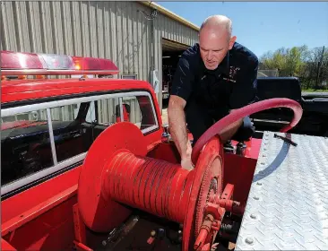  ?? NWA Democrat-Gazette/ANDY SHUPE ?? West Fork fire chief Mark Myers installs a new hose on the department’s brush truck Friday in West Fork. City officials plan to make $1.28 million in improvemen­t and expansion to administra­tive and police offices and to the city’s public library.