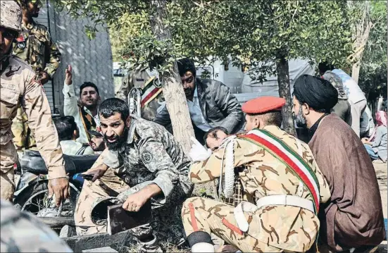  ?? BEHRAD GHASEMI / AFP ?? A cobert. Soldats, un clergue i diversos civils intenten protegir-se just després de l’atac, ahir a la ciutat d’Ahvaz, al sud-oest de l’Iran. Els militars participav­en en la desfilada anual per commemorar l’inici de la guerra amb l’Iraq