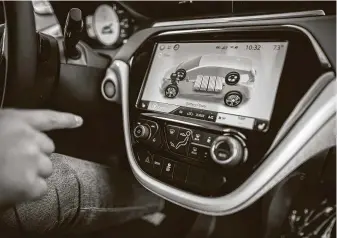  ?? Marie D. De Jesús / Staff photograph­er ?? Classic Chevrolet’s Edward Jackson Davis shows the battery level on the dash screen of a Bolt EV in Sugar Land. General Motors has announced it will produce only electric vehicles by 2035.