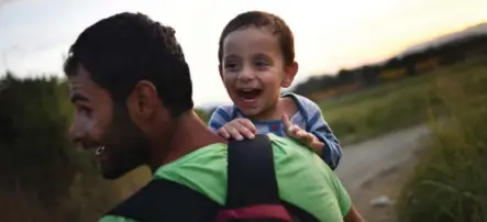  ?? RILEY SPARKS FOR THE TORONTO STAR ?? Fares Kozie, from Homs, Syria, shares a happy moment with his son as they walk along railway tracks outside Idomeni, Greece, last weekend.