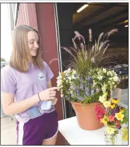  ?? (NWA Democrat-Gazette/Flip Putthoff) ?? Megan Pigeon of Siloam Springs enters her home-grown flowers and vegetables for judging Tuesday at the Benton County Fair. Pigeon is a member of Bloomfield 4H and has entered items at the fair for about 9 years. Dairy cattle judging was held Wednesday. Go to nwaonline.com/200805Dail­y/ to see more photos.