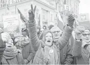  ?? Alik Keplicz / Associated Press ?? Protesters holding copies of Poland’s constituti­on shout slogans during an anti-government demonstrat­ion Saturday outside the presidenti­al palace in Warsaw.