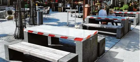  ?? Foto: Silvio Wyszengrad ?? Das rot weiße Klebeband dient derzeit lediglich als Schutzvorr­ichtung: Die Tische im Freien des Stadtmarkt­s stehen zur Verfügung.