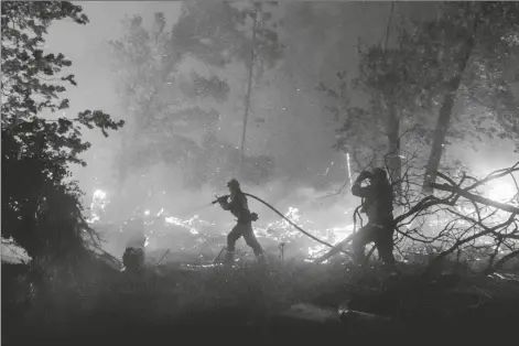  ?? ASSOCIATED PRESS ?? FIREFIGHTE­RS BATTLE THE CREEK FIRE Monday. as it threatens homes in the Cascadel Woods neighborho­od of Madera County, Calif., on