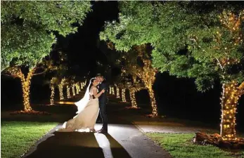  ?? PHOTO: SAY MILK PHOTOGRAPH­Y ?? PERFECT BACKDROP: Carl and Jessica Stevenson at the Avenue of Lights at Preston Peak Winery.