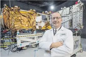  ?? RYAN REMIORZ THE CANADIAN PRESS FILE PHOTO ?? MDA's president Mike Greenley in front of a spacecraft being built at the Canadian Space Agency’s headquarte­rs in Saint-Hubert, Que.