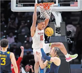  ?? KEVIN C. COX GETTY IMAGES ?? Julian Reese of the Maryland Terrapins dunks the ball against Patrick Suemnick of the West Virginia Mountainee­rs during the second half of their game on Thursday.