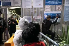  ?? Photograph: Guillermo Arias/AFP/Getty Images ?? A local police officer explains to a Mexican asylum seeker how to apply for asylum via the CBP One app, on the Mexican side of the San Ysidro port of entry at the US-Mexico border, on 11 May.