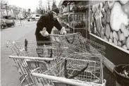  ?? Al Bello / Getty Images ?? Pat’s Farms worker John Fedash cleans and puts away carts. Sometimes he finds used gloves.