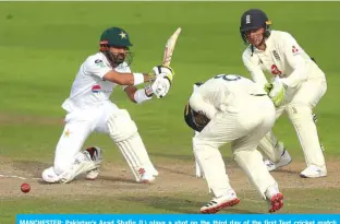  ?? — AFP ?? MANCHESTER: Pakistan’s Asad Shafiq (L) plays a shot on the third day of the first Test cricket match between England and Pakistan at Old Trafford in Manchester, north-west England.