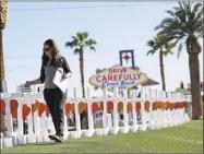  ?? Gregory Bull / Associated Press ?? Sherri Camperchio­li helps set up some of the crosses that arrived in Las Vegas Thursday to honor the victims of the mass shooting on Sunday in Las Vegas.