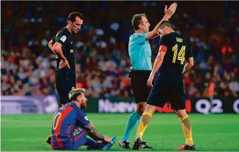  ?? AFP ?? Lionel Messi sits on the ground before leaving the pitch during the match against Atletico de Madrid at the Camp Nou stadium in Barcelona on Wednesday. Atletico and Barcelona drew, 1-1, which meant that Real Madrid, its mistake unpunished, had won.