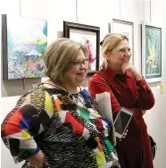  ?? Staff photo by Hunt Mercier ?? ■ Gay Durrant and Lauren Hehmeyer look at the artwork on display at the Four States Regional Art Club exhibit at the John F. Moss Library at Texas A&amp;M University—Texarkana.