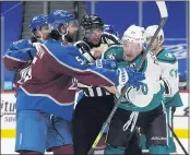  ??  ?? Colorado’s Greg Pateryn, left, joins linesman Mark Wheler, center, in trying to hold back the Ducks’ Nicolas Deslaurier­s from fighting Avalanche center Nazem Kadri.