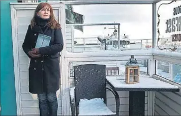  ??  ?? La escritora. Auður Ava Ólafsdótti­r, esta semana, en la terraza del Café Haití de Reikiavik, junto a un ejemplar de su última novela, Cicatriz, aún inédita en España