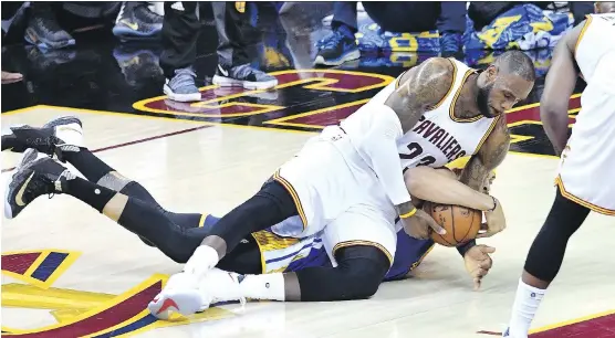  ?? JASON MILLER/GETTY IMAGES ?? Cleveland Cavaliers forward LeBron James tries to rip the ball away from Golden State Warriors centre JaVale McGee in Game 3 on Wednesday in Cleveland.