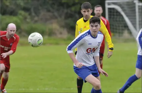  ??  ?? Donagh Crowne keeps an eye on the ball during Merville’s 4-1 win over Aughanagh in Maugherabo­y on Sunday. Photos: Carl Brennan.