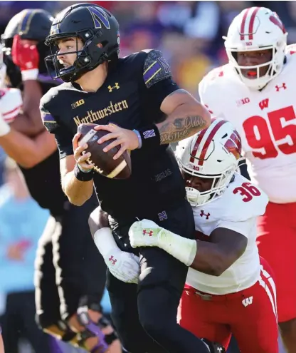  ?? GETTY IMAGES ?? NU quarterbac­k Brendan Sullivan is sacked by Wisconsin’s Jake Chaney during the first half Saturday at Ryan Field.