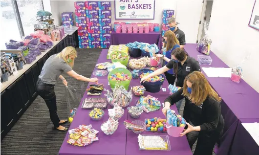  ?? PHOTOS BY PAUL W. GILLESPIE/CAPITAL GAZETTE ?? Employees with KCW Engineerin­g Technologi­es and House of Ruth assemble care packages, called Amy’s Baskets, for clients of the House of Ruth, from donations by the KCW and a group of school children on Wednesday.