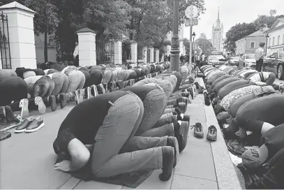  ?? — Gambar AFP ?? TUNTUT KESAKSAMAA­N: Ratusan penduduk Muslim bersolat di hadapan kedutaan Myanmar di tengah Moscow, Rusia semalam tanda sokongan buat Rohingya.