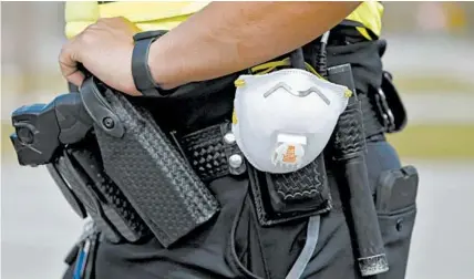  ?? MIC SMITH/AP ?? A police officer carries a protective mask around his gun belt on Monday in North Charleston, South Carolina.