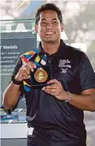  ??  ?? Sports Minister Khairy Jamaluddin shows a Sea Games medal at Royal Selangor, Setapak yesterday.