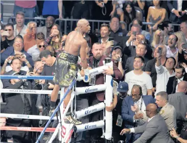  ?? Picture: EPA ?? FEELING LIKE A MILLION BUCKS AND MORE: Floyd Mayweather climbs the ring ropes to celebrate his win against Conor McGregor in Las Vegas