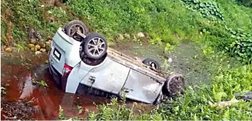  ??  ?? The car turned turtle and landed in the roadside drain.