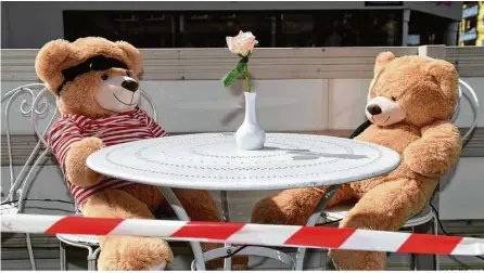  ?? Foto: Felix Hörhager/dpa ?? Müssen sie ihre Plätze bald räumen? Zwei Teddybären sitzen im Außenberei­ch des Cafes Jasmin in München.