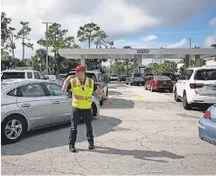  ?? AMANDA INSCORE/ USA TODAY NETWORK ?? Josiah Wetmore directs traffic at the Costco gas pumps in Fort Myers as residents prepared for Idalia. The storm was forecast to hit Florida’s Gulf Coast as a major hurricane Wednesday with high winds and storm surge.