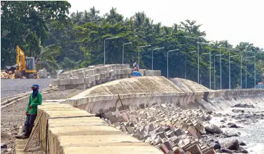  ?? BING GONZALES ?? A CONSTRUCTI­ON worker takes a rest at the seawall in the ongoing coastal road project in Barangay Talomo Proper, Talomo District.