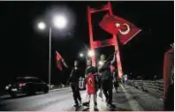  ??  ?? Government supporters wave Turkish flags