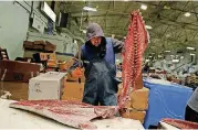  ??  ?? A fishmonger cuts the loins from a yellowfin tuna imported from South America at the New Fulton Fish Market in New York on Dec. 14. More than 90 percent of all seafood that ends up on U.S. dinner tables is imported.