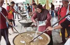  ??  ?? SAKINAH memasukkan bahan ke dalam bubur asyura.