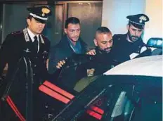  ?? AFP ?? Roberto Spada (second right), brother of Ostia clan chief Carmine, leaves the barracks of the Carabinier­i to be brought into jail, Ostia, Italy, on Thursday.