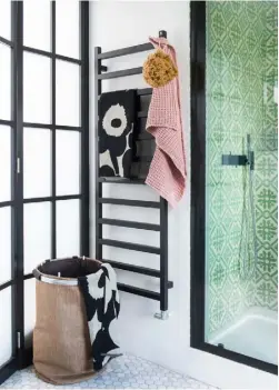  ??  ?? SHOWER ENCLOSURE The patterned wall tiles provide a stunningco­ntrast to the sleek black shower frame and taps