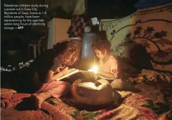  ?? — AFP ?? Palestinia­n children study during a power cut in Gaza City. Residents of Gaza, home to 1.8 million people, have been experienci­ng for the past two weeks long hours of electricit­y outage.