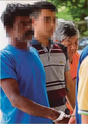  ?? MOHAMAD
PIC BY HAZREEN ?? The lorry driver (left) being escorted by policemen outside the magistrate’s court in Seremban yesterday.