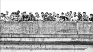  ??  ?? Crowds arrive at the scene where a body was found floating under a bridge.