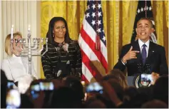  ?? (Yuri Gripas/Reuters) ?? US PRESIDENT Barack Obama, with first lady Michelle Obama, addresses a Hanukka reception at the White House last month.