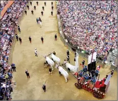  ?? Rick Steves’ Europe/RICK STEVES ?? The crowd looks on as an oxen cart pulls the Palio banner through Siena’s main square.