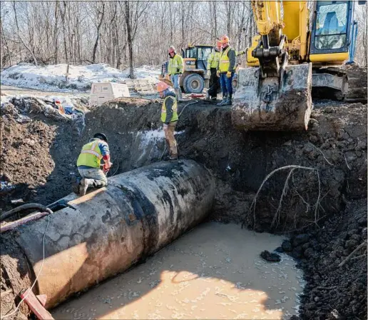  ?? Photos by Jim Franco / Times Union ?? A Luizzi Brothers crew works on a new 60-inch pipe Wednesday in Troy as part of a replacemen­t project with water mains expected to last at least 250 years. The mains will carry 21 million gallons of water daily from Tomhannock Reservoir to a treatment plant.