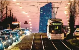  ?? MICHAEL PROBST/AP ?? A tram passes traffic as it heads toward the European Central Bank in Frankfurt, Germany. Eurozone inflation persists but is down from its October peak of 10.6%.