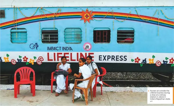  ?? AFP ?? ■ Nurses sit outside the Lifeline Express during a stop at a railway station in Jalore in India’s Rajasthan state.