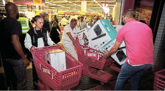  ?? Picture: THEO JEPTHA ?? MAKING THE MOST OF IT: Customers make their way out of Game in Vincent Park, East London, after completing their purchases.