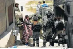  ?? ODAY DAIBES / EFE ?? Militares israelíes hablan con una palestina tras ser asesinado un soldado.