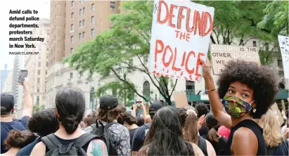  ?? RAGAN CLARK/AP ?? Amid calls to defund police department­s, protesters march Saturday in New York.