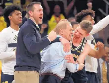  ?? JULIE JACOBSON/ASSOCIATED PRESS ?? Michigan forward Moritz Wagner hugs coach John Beilein after the Wolverines beat Purdue in the Big Ten tournament title game. It was Michigan’s second straight conference tournament title.