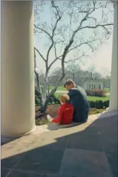  ?? SUBMITTED PHOTO ?? President John F. Kennedy enjoys a contemplat­ive moment with son John Jr. while sitting on the porch of the White House.